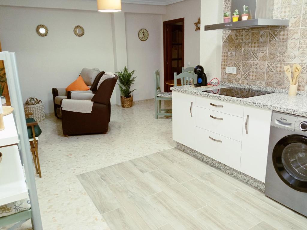 a kitchen and living room with a couch at Apartamento La Viñuela in Córdoba