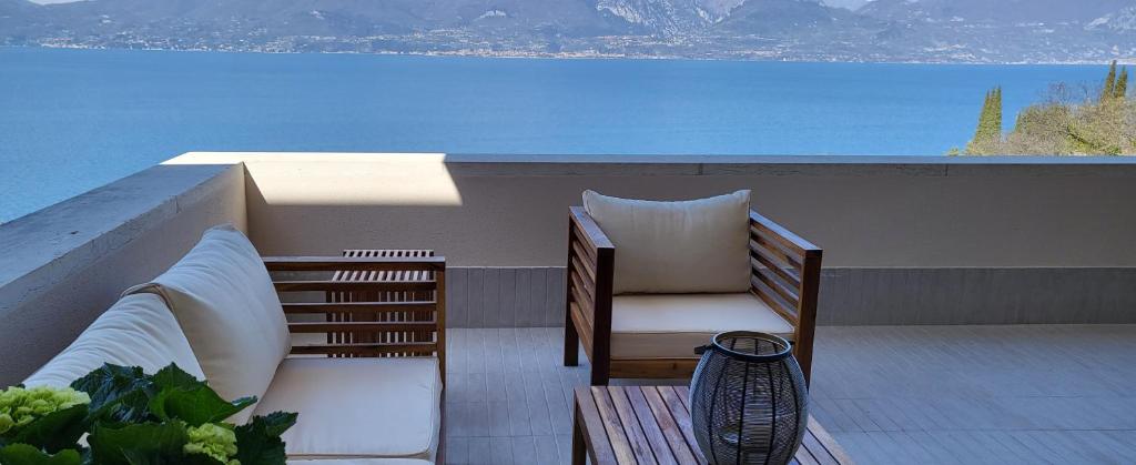 a balcony with two pillows and a view of the ocean at La maison sur mer in Torri del Benaco