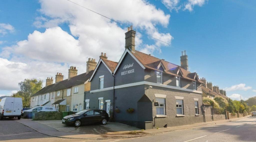 un bâtiment avec une voiture garée devant lui dans l'établissement Aylesford Guesthouse, à Kent