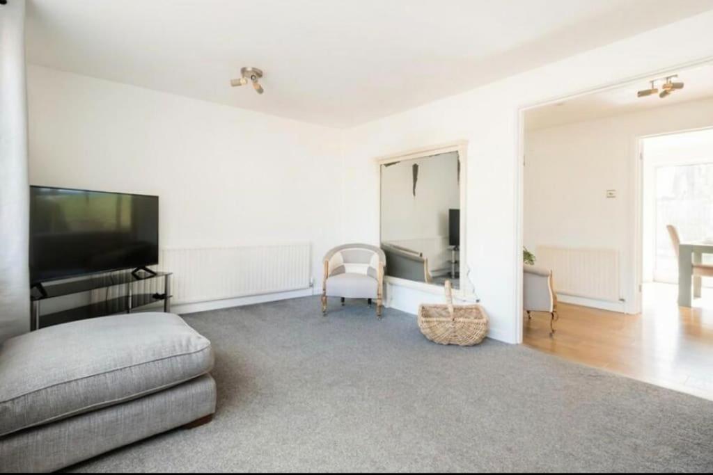 a white room with a bed and a flat screen tv at Cosy 4 Bedroom Town House Ample Parking & Netflix in Leominster