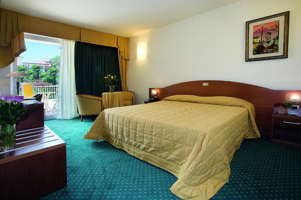A bed or beds in a room at Hotel Capri Bardolino 3S