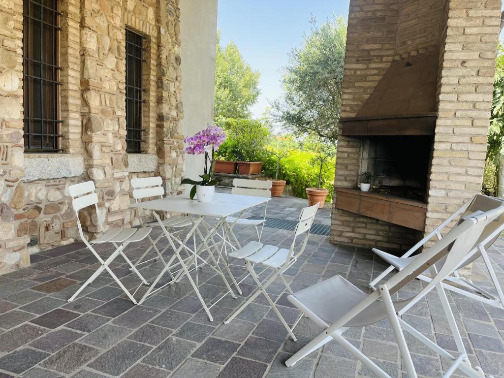 a table and chairs on a patio with a fireplace at Il borgo fra i laghi in Monzambano