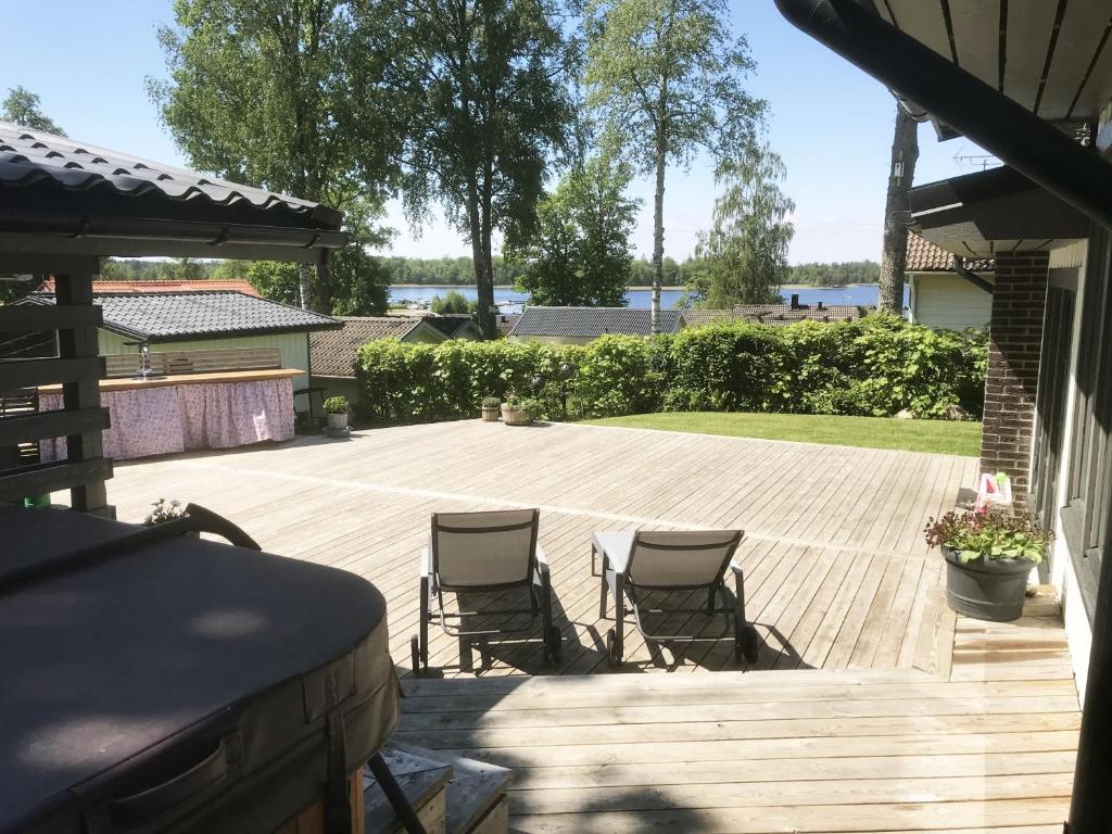 a patio with two chairs on a wooden deck at Nice holiday home in Tallbacken outside Ljungby in Bolmstad