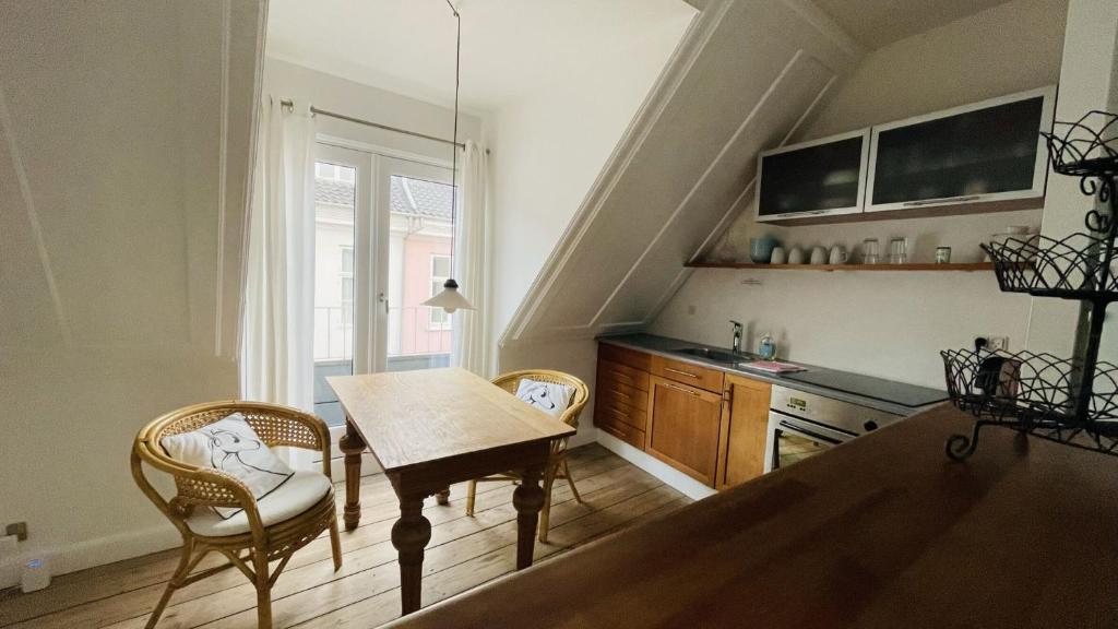 kuchnia ze stołem i krzesłami w pokoju w obiekcie ApartmentInCopenhagen Apartment 298 w Kopenhadze