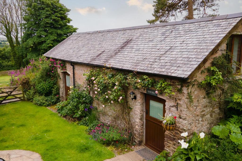 ein Steinhaus mit einem grauen Dach in der Unterkunft Rosehill Barn -a tranquil rural barn conversion in Barnstaple