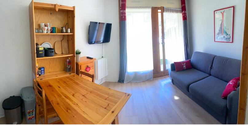 sala de estar con sofá azul y mesa de madera en Studio 4 personnes - accès direct remontées mécaniques, en Les Contamines-Montjoie