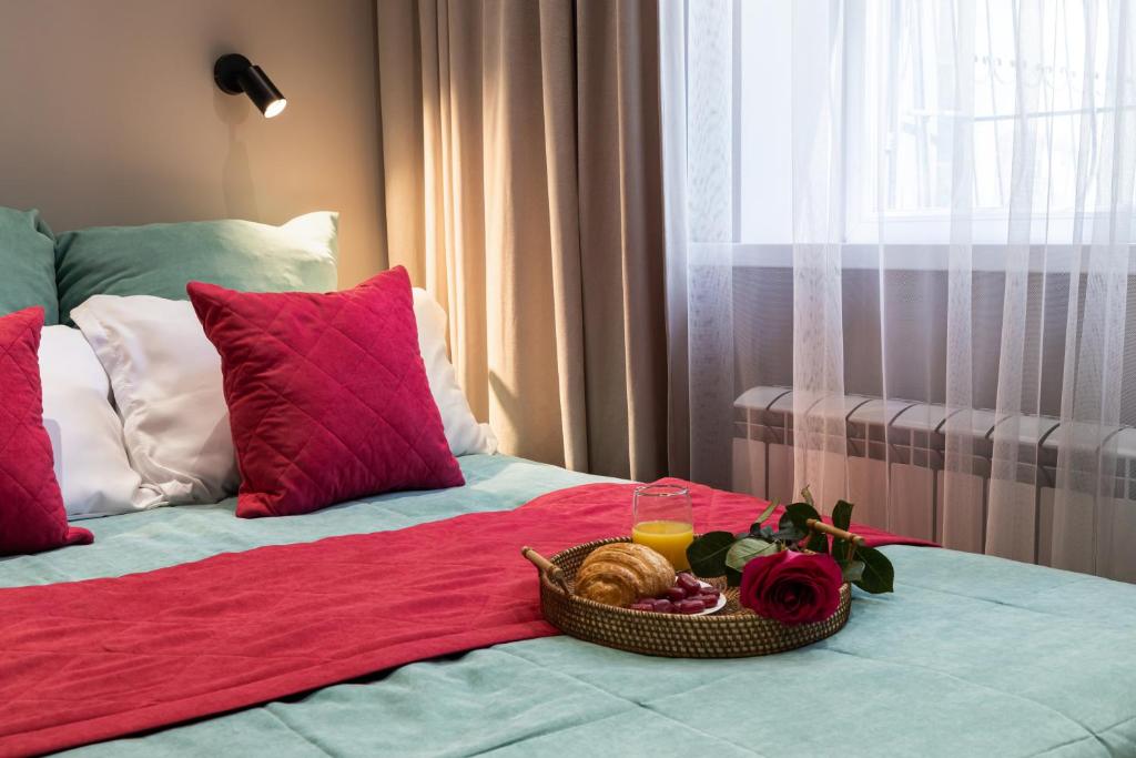 a bed with a basket of food and a drink on it at Апартаменты Comfort Life 91 in Almaty