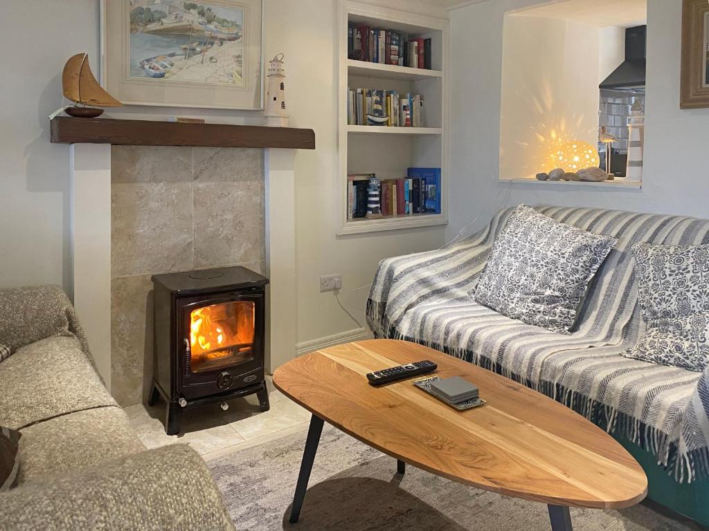 Cottage 170 - Roundstone في راوندستون: غرفة معيشة مع أريكة ومدفأة