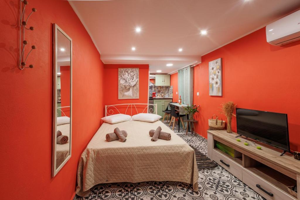 a red room with a bed and a flat screen tv at Casa Lefteritsa in Corfu
