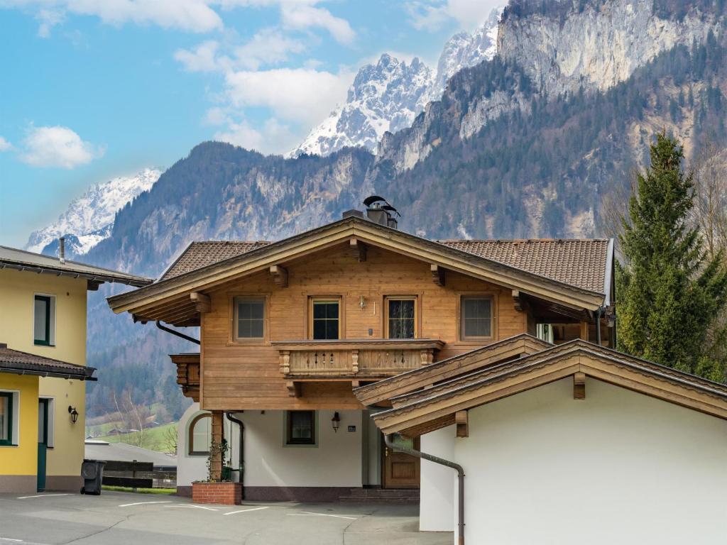 a wooden house with mountains in the background at Ferienwohnung Stock in Kirchdorf in Tirol