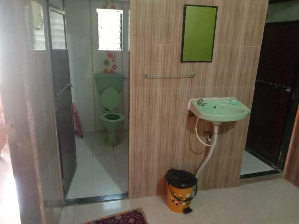 a bathroom with a toilet and a sink and a shower at Advait Holiday Home in Nagaon