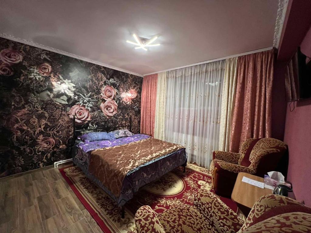 a bedroom with a bed and a chair at Комната Gold Rose in Chişinău