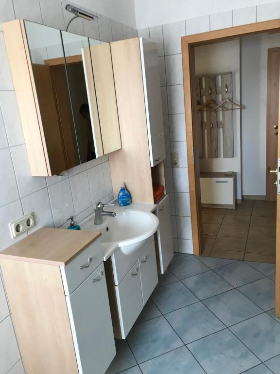 a bathroom with a sink and a mirror at Ferienwohnung Familie Nahrstedt Erdgeschoß in Löbau