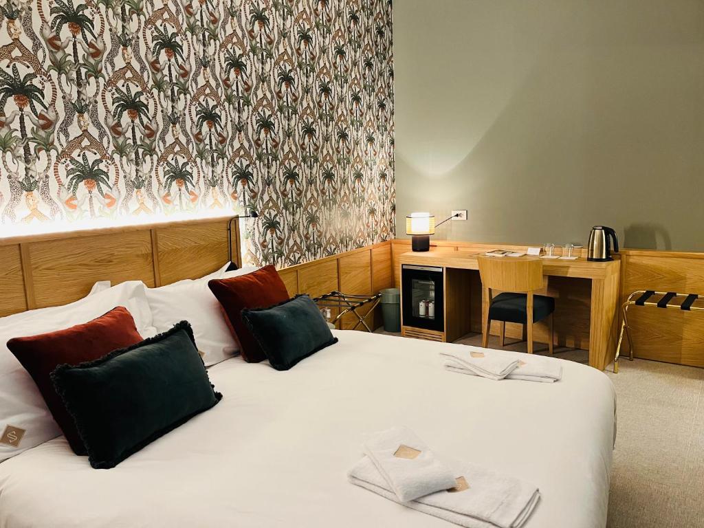 a hotel room with two beds and a desk at Smallis Apartment in Conversano