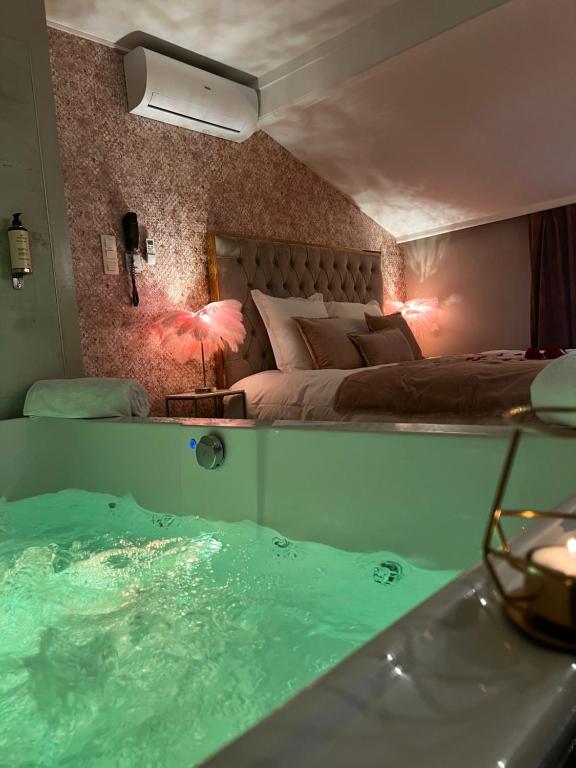 um quarto com uma banheira com uma cama e uma cama em Hôtel Mademoiselle em Liège