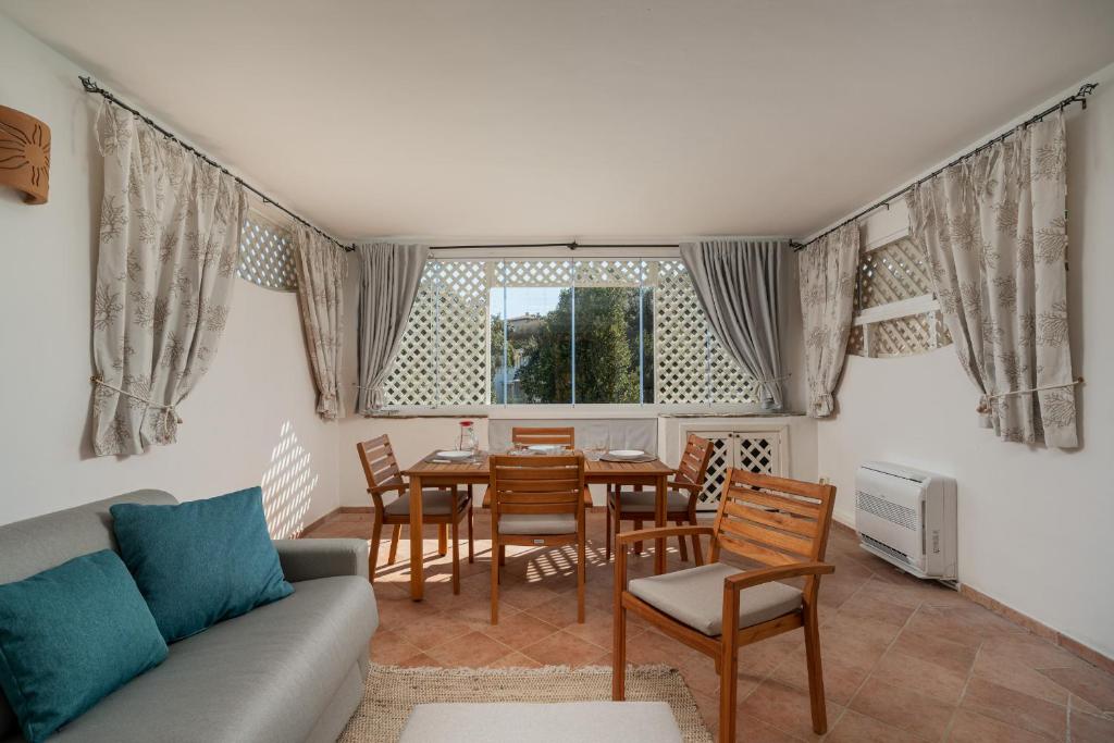 a living room with a couch and a table and chairs at Sweet Mavy Incantevole Dimora by Wonderful Italy in Porto Rotondo