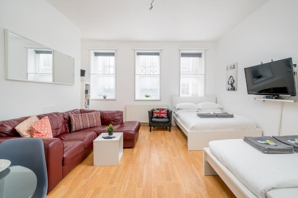 a living room with a couch and a tv at Soho Apartment Sleeps 4, Covent Garden & Leicester Square in London