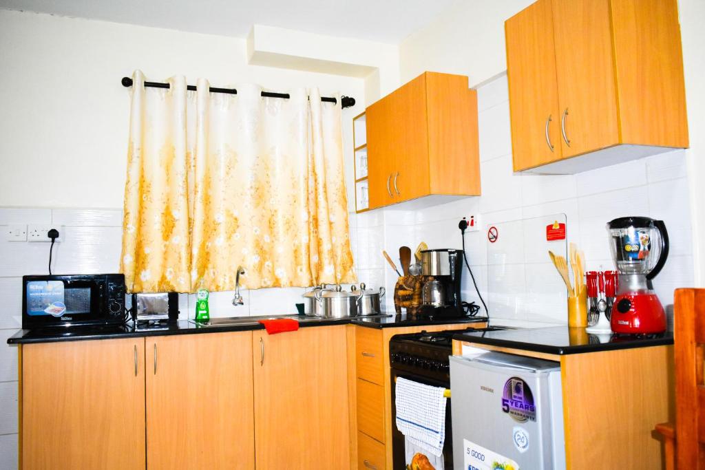 a kitchen with wooden cabinets and a window at Affordable furnished apartments at the city centre in Nairobi