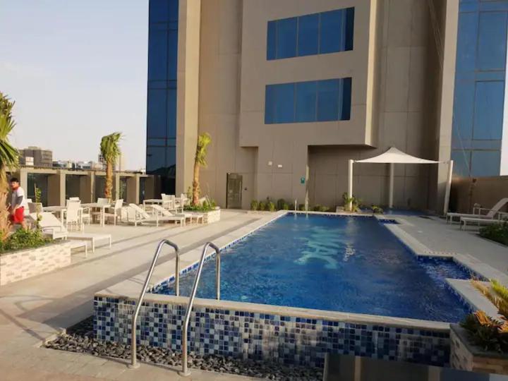 une piscine en face d'un bâtiment dans l'établissement 4Leisure Suites DAMAC Esclusiva Towers, à Riyad