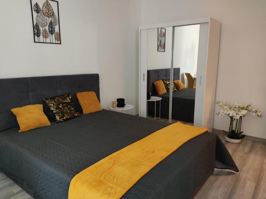 a bedroom with a large bed and a mirror at Love Lair Apartman in Miskolc
