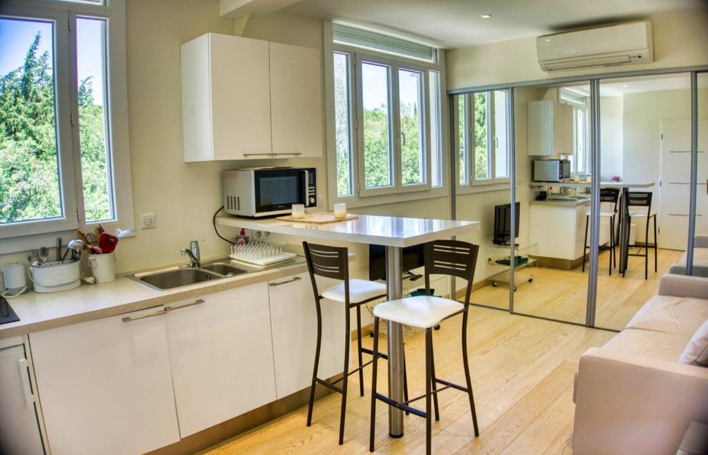 - une cuisine avec un comptoir et des chaises dans la chambre dans l'établissement Cannes charming studio 50 meters from the beach !!, à Cannes