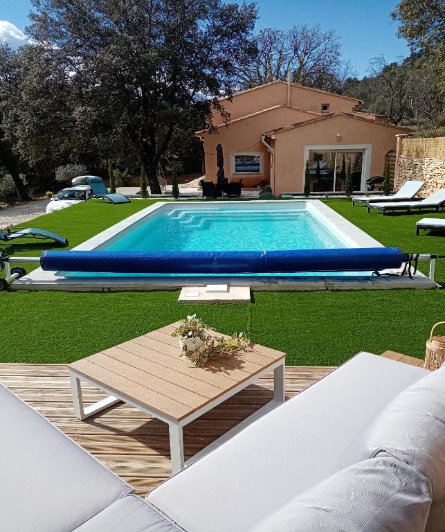 - une piscine avec une table en face d'une maison dans l'établissement Le Jas des Blaquets, à Moissac-Bellevue