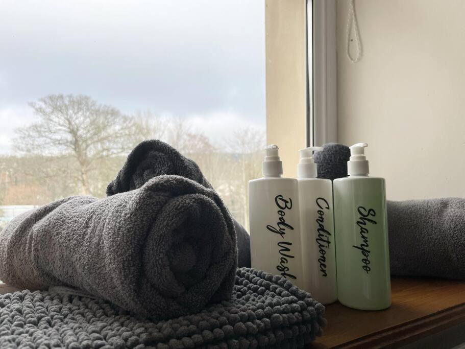 a towel and two shampoo bottles on a window sill at Rose Cottage Trecynon Traditional 2 bed cottage Zip World Beacons Bike in Aberdare