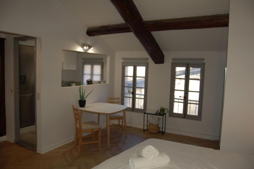 une cuisine et une salle à manger avec une table et des chaises dans l'établissement Noa - Mont Piete Studio intramuros -, à Avignon