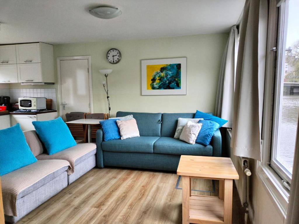 a living room with a blue couch and a table at Apartment at the East side, close to center in Amsterdam