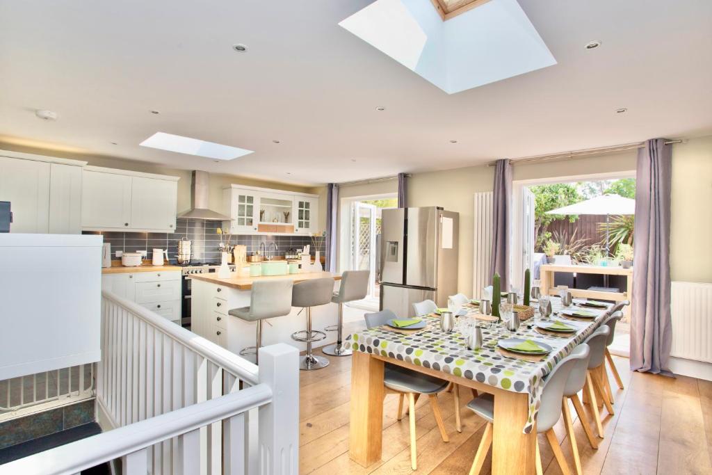 cocina y comedor con mesa y sillas en Luxury Home - Hot Tub - Pool Table - Cinema Room - Close to Beach en Bournemouth