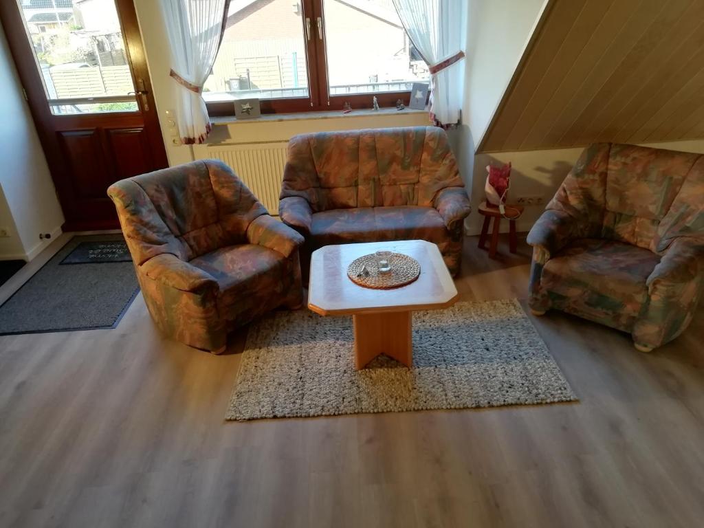 a living room with two chairs and a coffee table at Ferienwohnung Gartenblick mit Balkon in Maasholm