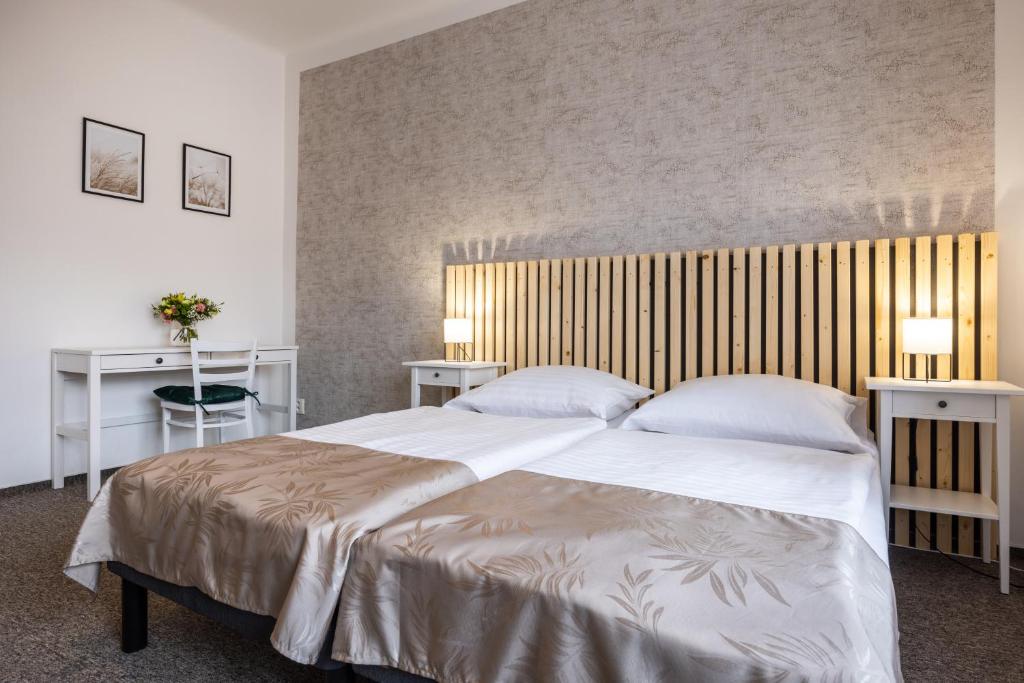 a bedroom with a large white bed with two tables at Penzion Tašner in Litomyšl