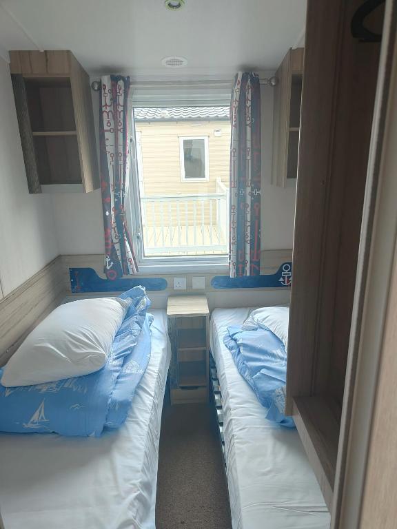 two beds in a small room with a window at Haven Holiday Park 3 bedroom Cala Gran Fleetwood in Thornton