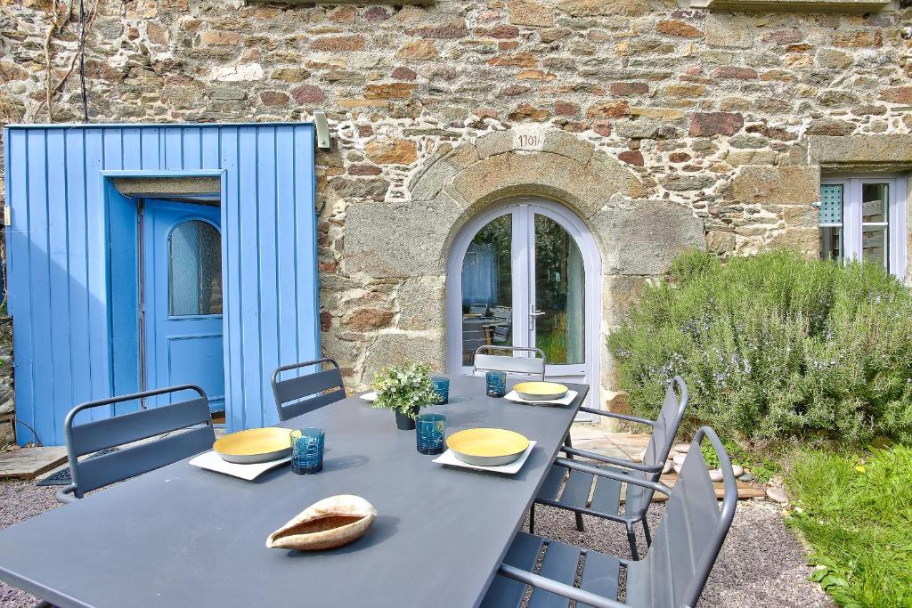 a blue table and chairs in front of a building at Charmante maison bretonne pour 6, a Saint-Suliac in Saint-Suliac