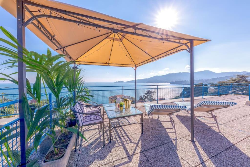 a patio with a table and chairs and an umbrella at [Vista Mare Portofino] Terrazza • Free Parking • Wi-fi in Rapallo