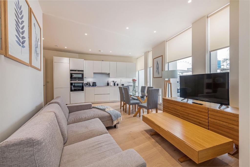 a living room with a couch and a flat screen tv at StayLux Waterloo in London