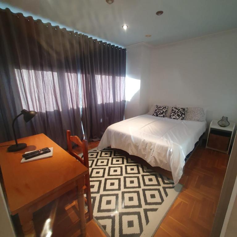 1 dormitorio con cama, mesa y escritorio en Apartamento en Gijon, en Gijón