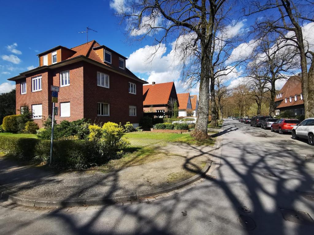 a large brick house on a street with a tree at HR Stadtwald Villa Honigbach in Coesfeld
