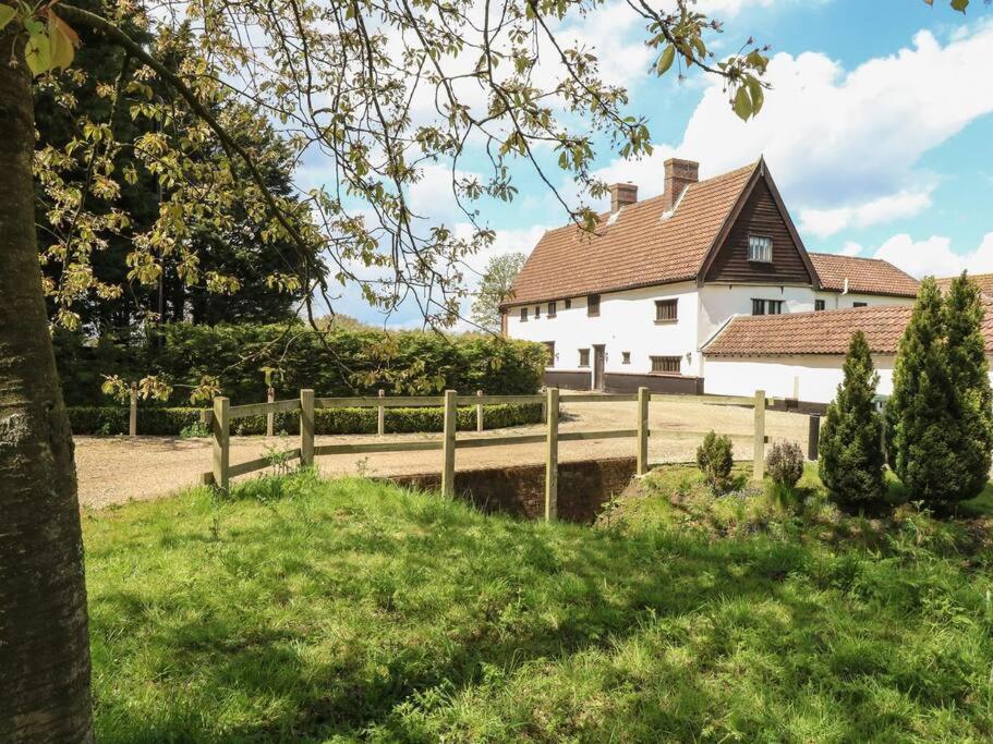 ein weißes Haus mit einem Zaun und einem Hof in der Unterkunft Beautiful 10 Bed Oak beamed Country House in Tibenham