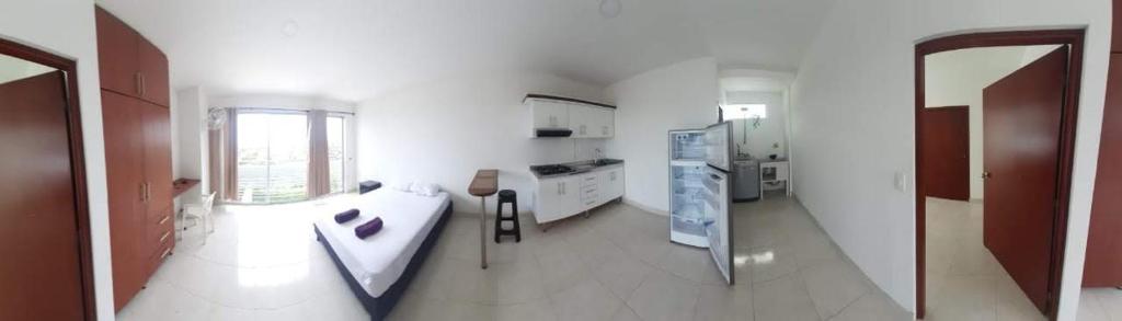 a kitchen with white walls and a large window at Apartaestudio Sendero Primavera in Neiva