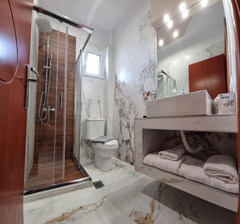 y baño con ducha, aseo y lavamanos. en PREMIUM SUITES, en Ofrinion