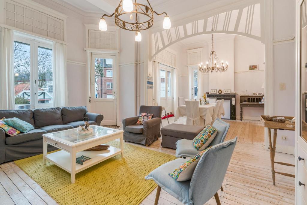 a living room with a couch and a table at Oceanide - Gerenoveerde luxe villa vlak bij het strand in De Haan