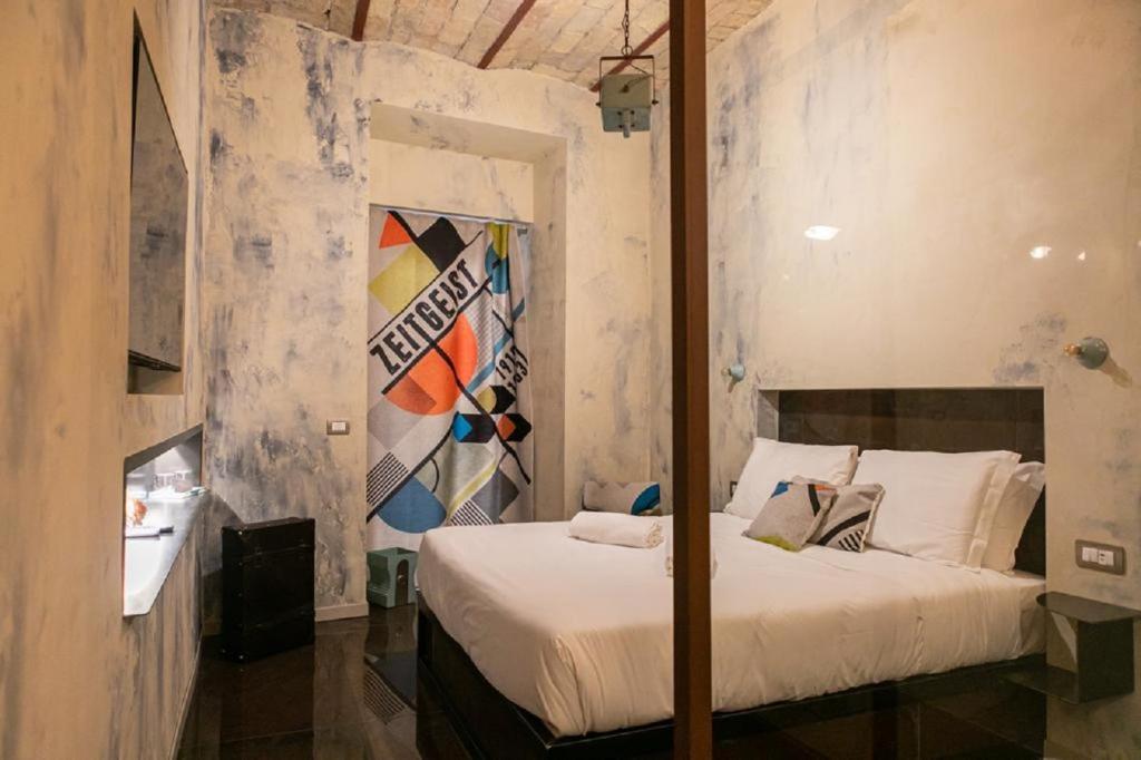 Schlafzimmer mit einem Himmelbett an der Wand in der Unterkunft Bhr Cavour 150 in Rom