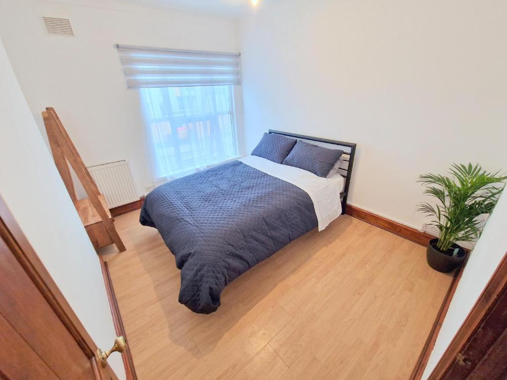 a bedroom with a bed and a potted plant at Two bedroom apartment near Lewisham Station in London