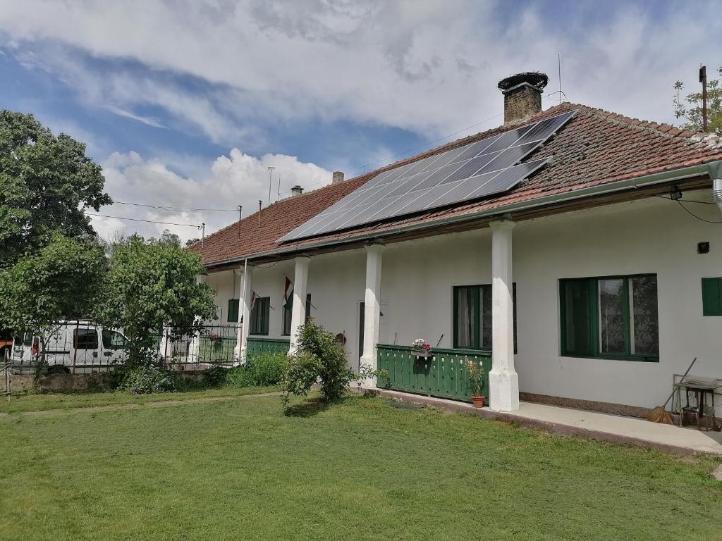 uma casa com muitos painéis solares no telhado em ÁGÓC Vendégház em Alsóberecki