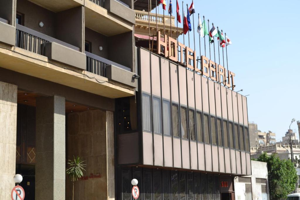 um edifício de hotel com bandeiras em cima em Beirut Hotel Cairo no Cairo