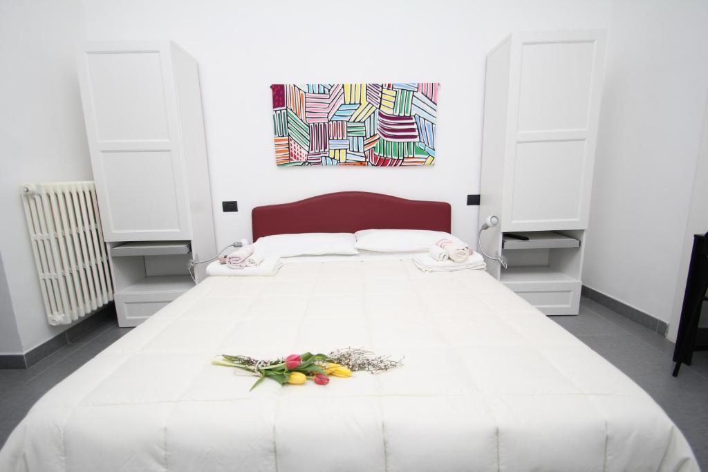 1 dormitorio con 1 cama blanca grande y una pintura en la pared en Angoletto Young B&B, en Avellino