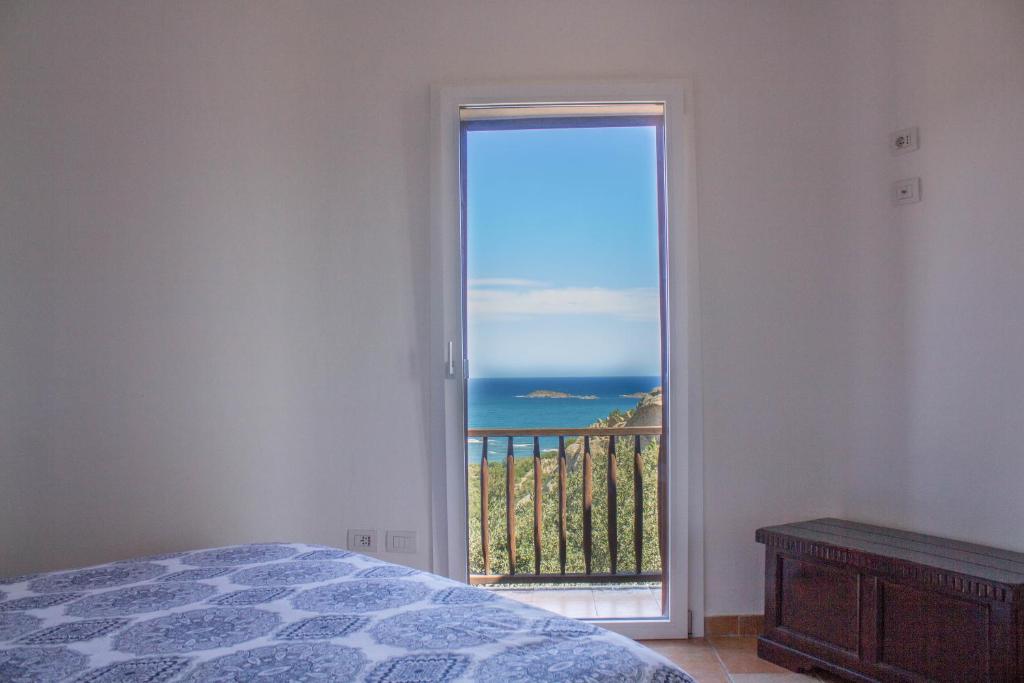 a bedroom with a view of the ocean from a door at Stella Marina- Luxury Sea View in Porto Cervo! in Porto Cervo