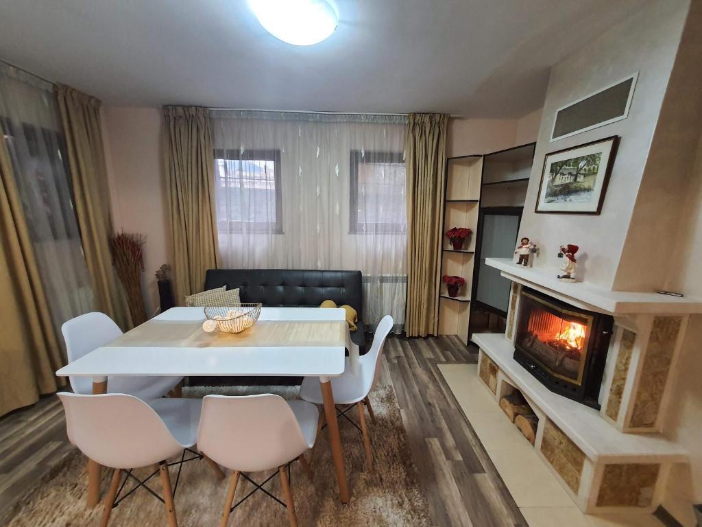 - un salon avec une table et une cheminée dans l'établissement Апартамент Зимна приказка, à Chepelare