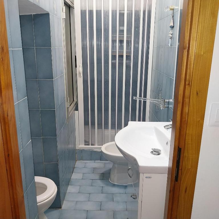 ein Badezimmer mit einem weißen Waschbecken und einem WC in der Unterkunft ANFORA HOUSE in Genua